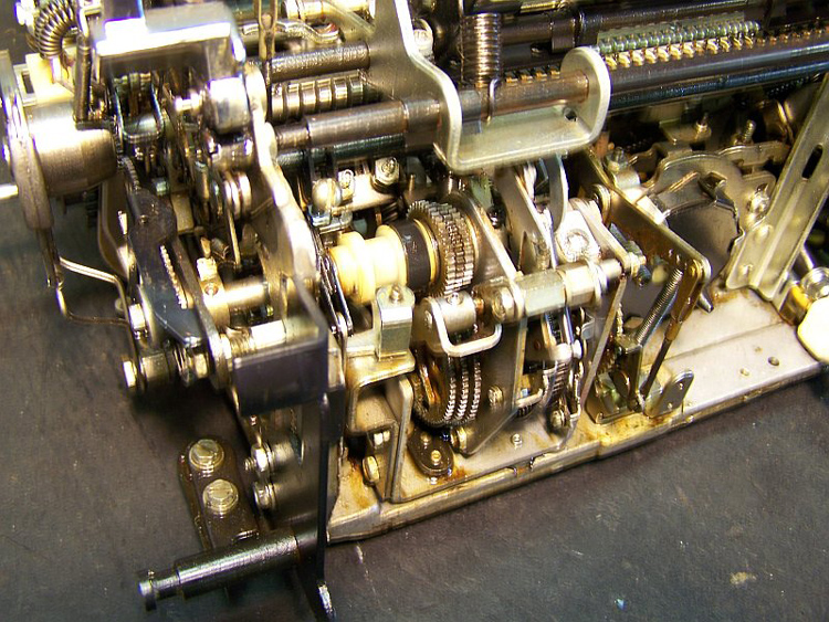 The three sets of incremental-size gears allow the three different escapement pitches. A gear changer engages only one set at a time.