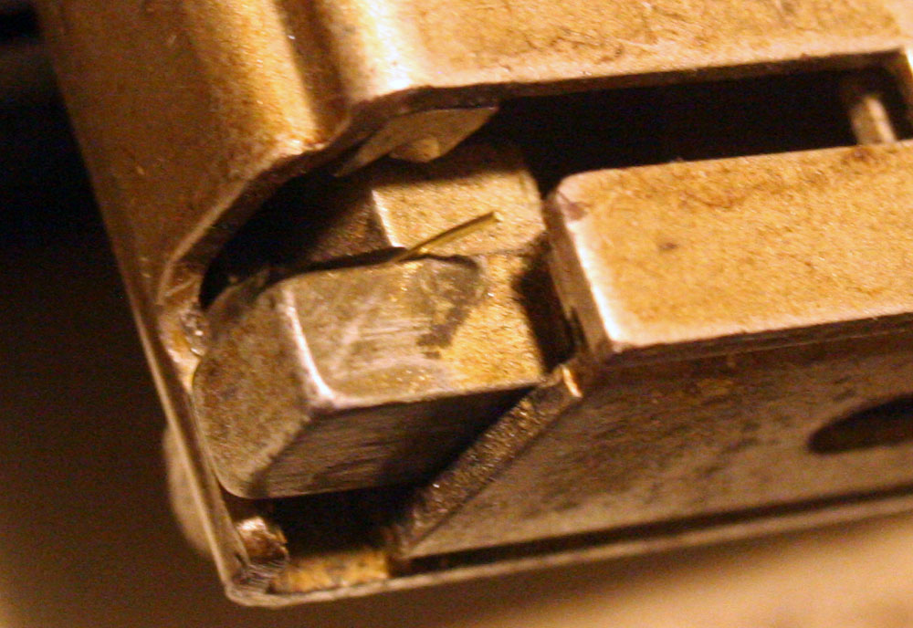 The business end - the end of the brass wire, ready to be chopped off the spool and turned into a staple.